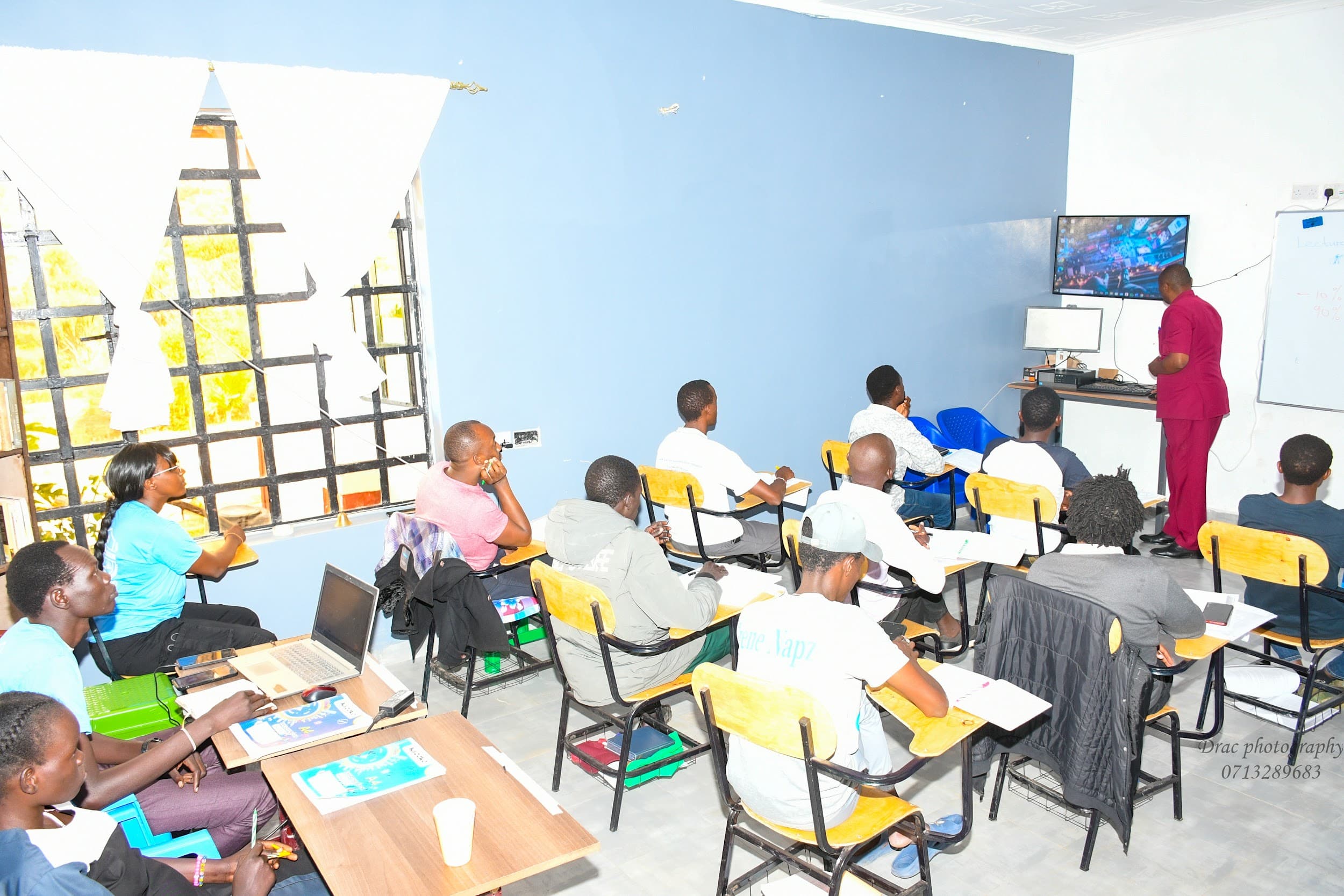 Lecturer teaching a class using a screen